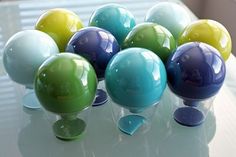 there are many different colored balls on the glass table top in front of each other