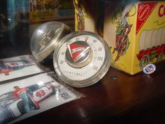 an old time clock sitting on top of a wooden table next to boxes and other items