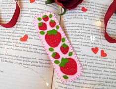 a bookmark made to look like strawberries with green leaves and hearts on it