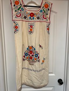 This fabulous 100% Cotton Puebla Style Dress is hand made and hand embroidered with bright floral design!  The sleeves and hem has natural crocheted trim at the edge of sleeve and hem!  Great spring and summer dress as well as topping it off with a jean jacket, kimono or poncho for the fall! This fabric looks is not the thin fabric of the normal Puebla dress! Measurements! Size Medium Chest: 38" (that is a flat measure) Hip:  45@ Length:  41" Care: Cold wash, delicate, inside out! Hang dry Do not machine dry Press on inside out  Dry clean optional  Shipping: Free regular shipping, expedited shipping is an extra charge! Return policy: Buyer pays for return shipping, no returns after 7 days of receiving product!   Seller must be notified. Puebla Dress, Natural Dress, Nature Dress, Dress Measurements, Style Dress, Womens Clothing Tops, Jean Jacket, Summer Dress, Hand Embroidered