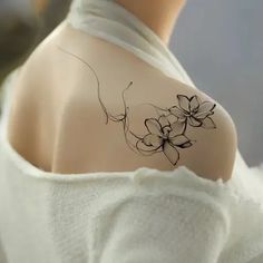 the back of a woman's shoulder with flowers on it