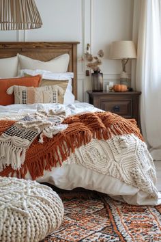 a bed with an orange and white blanket on top of it