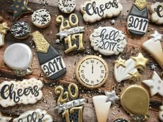 decorated cookies with numbers, stars and other decorations on top of a wooden table next to a clock