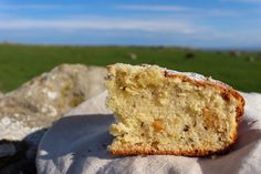 a half eaten piece of cake sitting on top of a white cloth next to a green field