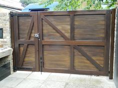 a wooden gate is open on the side of a house