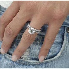 a close up of a person's hand with a diamond ring on their finger