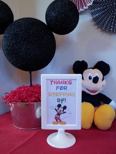 there is a stuffed mickey mouse next to a sign that says thanks for stopping by