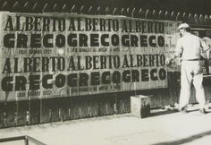 a man standing next to a large sign