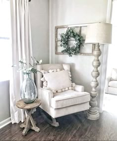 a white chair sitting next to a window in a living room