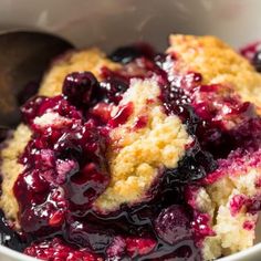 blueberry cobbler in a white bowl with a spoon