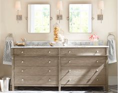 a bathroom with two mirrors above the sink and an old dresser in front of it