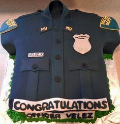 a cake that is shaped like a police officer's uniform with congratulations written on it