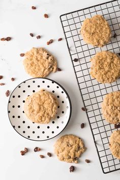 oatmeal raisin cookies cooling on a wire rack next to a bowl of raisins