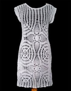 a white crocheted dress on a mannequin dummy with an orange handle