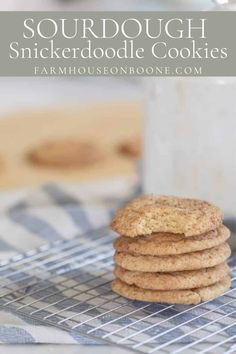 a stack of cookies sitting on top of a cooling rack next to a glass of milk