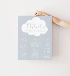 a person holding up a birthday card with a cloud on the front and back, which reads patrick's first birthday