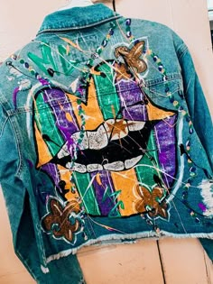 a jean jacket with an image of a cat on it's back and butterfly patches