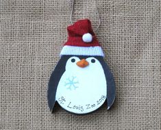 a penguin ornament with a red hat on it's head and name