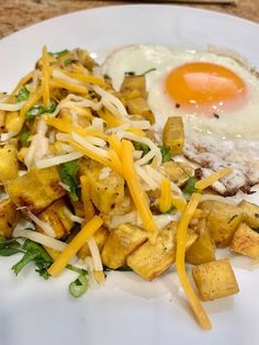 a white plate topped with hash browns and an egg