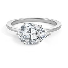 an oval cut diamond engagement ring on a white background