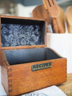 an old wooden box sitting on top of a table with utensils in it