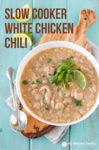 a white bowl filled with soup and garnished with cilantro, limes, and mint