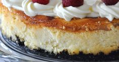 a cake with white frosting and raspberries on top sitting on a plate