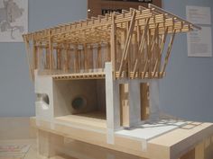 a model of a house made out of wood sticks and plywood planks on display