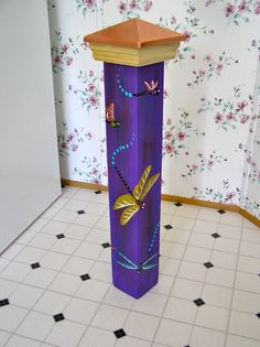 a tall purple pillar sitting on top of a tiled floor