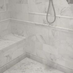 a white marble bathroom with a shower head