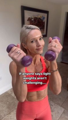 a woman holding two purple dumbs in front of her face with the caption if anyone says light weights aren't challenging