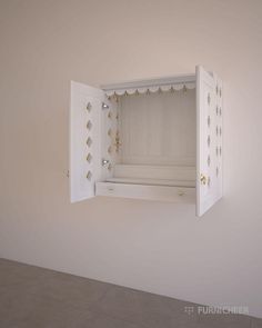 an open white box with gold decorations on the inside is shown in this empty room