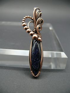 The celestial blue hues of the sandstone, are reminiscent of a starry night sky. Wearing blue sandstone gemstone jewellery is believed to enhance courage, confidence, and vitality, promoting a sense of inner strength and resilience. It is associated with soothing energies that help calm the mind and alleviate stress, fostering mental clarity and emotional stability. Many also believe that blue sandstone aids in achieving goals and manifesting dreams, encouraging a positive outlook on life. This Elegant Blue Copper Jewelry, Celestial Style Wire Wrapped Pendant Jewelry, Blue Mystical Pendant Jewelry, Mystical Blue Pendant Jewelry, Blue Gemstone Copper Jewelry, Blue Gemstone Jewelry In Copper, Blue Copper Gemstone Jewelry, Celestial Bronze Jewelry Gift, Mystical Copper Pendant Jewelry