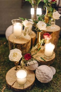 candles and flowers are arranged on wood slices