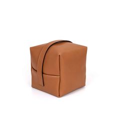 the tan leather bag is folded up and ready to be used as a shoulderbag