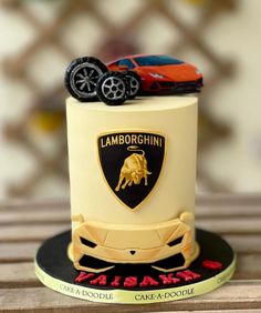 a birthday cake with a lambino racing car on top and the word lamborgchinn written in gold