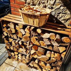 a pile of wood sitting next to a brick wall