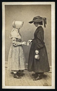 an old photo of two women in dresses and hats