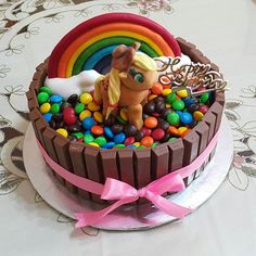 there is a cake decorated with candy and a horse in the middle on top of it