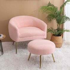 a pink chair and footstool in a living room with a potted plant