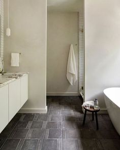 a white bath tub sitting next to a bathroom sink