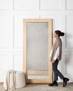 a woman standing in front of a large mirror