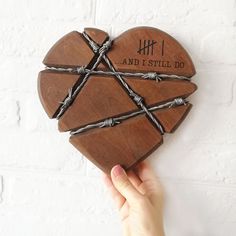 a wooden heart with barbed wire around it that says and i still do on the front