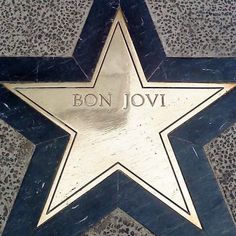 a star on the ground with bon jovi written on it's side in gold and black