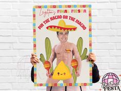 a man holding up a poster with an image of a shirtless man wearing a sombrero