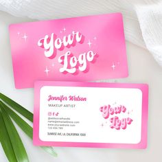 two business cards with the words you're logo printed on them next to some green leaves