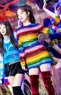 two girls in colorful dresses and thigh high boots on the catwalk at a fashion show