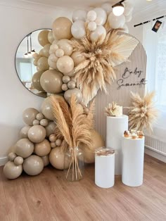 some balloons are hanging on the wall in front of a mirror and vases filled with flowers