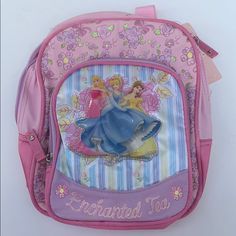 a pink and blue backpack with princesses on the front, sitting against a white wall