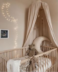 a baby crib with a teddy bear in it and some lights on the wall